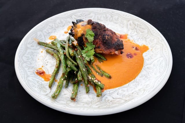 pan-roasted chicken thigh in chili crisp sauce with her corvair beans